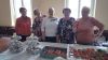 Seniorki pozują do zdjęcia przy słodkościach